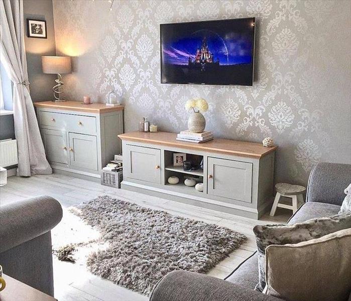 Room with Wallpaper, Long Drapes, Wooden Furniture and Television mounted to wall